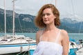 Beautiful woman in a white dress standing on the pier.