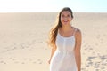 Beautiful woman with white dress walking on Corralejo desert dunes looking at camera, Fuerteventura, Spain Royalty Free Stock Photo