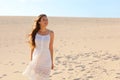 Beautiful woman with white dress walking on dunes in desert, Corralejo, Fuerteventura, Spain Royalty Free Stock Photo
