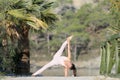 A beautiful woman in a white gymnastic jumpsuit does yoga pose with elbow support Royalty Free Stock Photo