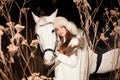 Beautiful woman and white horse, winter evening walk