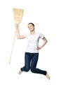 Beautiful  woman in a white T-shirt jumping holds a broom in her hands isolated on a white background Royalty Free Stock Photo