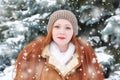 Beautiful woman on winter outdoor, snowy fir trees in forest, long red hair, wearing a sheepskin coat Royalty Free Stock Photo