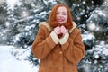 Beautiful woman on winter outdoor, snowy fir trees in forest, long red hair, wearing a sheepskin coat Royalty Free Stock Photo