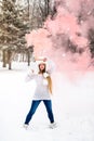 Beautiful woman in winter park holding red smoke bomb Royalty Free Stock Photo