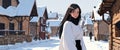 beautiful woman in winter in a snowy village in winter.