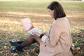 Beautiful woman working on laptop in the park. Attractive freelancer on outdoors. Royalty Free Stock Photo