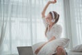 Beautiful woman working and listening the music on her bed