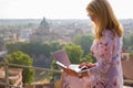 Woman working on phone and laptop with city in background Royalty Free Stock Photo