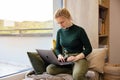 Women's remote work wellness. Work-life balance for women. A woman using laptop in the coziest place