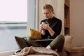 Women's remote work wellness. Work-life balance for women. A woman using laptop in the coziest place