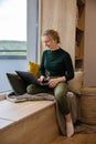 Women's remote work. Work-life balance for women. A woman using laptop in the coziest place