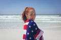 Beautiful woman wrapped in an american flag at beach Royalty Free Stock Photo