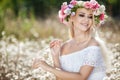 Beautiful woman with a wreath of flowers in summer field Royalty Free Stock Photo