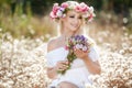 Beautiful woman with a wreath of flowers in summer field Royalty Free Stock Photo