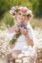 Beautiful woman with a wreath of flowers in summer field Royalty Free Stock Photo