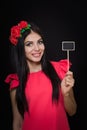 Beautiful woman with a wreath of red flowers holds a wooden plaque Royalty Free Stock Photo