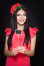 Beautiful woman with a wreath of red flowers holds a wooden plaque Royalty Free Stock Photo