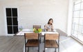 Beautiful woman writing and thinking menu on table at dining room