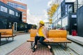 Beautiful woman in yellow beret sits on the street on the bench, depicts emotions. Summer time, yellow colors Royalty Free Stock Photo