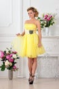 Beautiful woman in yellow dress in luxury studio. Royalty Free Stock Photo