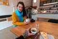 Beautiful Woman in Yellow Sweater And Blue Scarf Drinking Hot Tea Or Coffee And Looking at Boyfriend. first person view Royalty Free Stock Photo