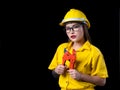 A beautiful woman in the yellow technician uniform holding a construction tool