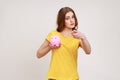 Beautiful woman of young age in yellow T-shirt investing in bitcoins, holding piggy bank and Royalty Free Stock Photo