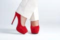 Beautiful womanish feet in red shoes standing on light background. Royalty Free Stock Photo