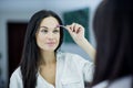 Womem in mirror clean make-up eyebrows Royalty Free Stock Photo