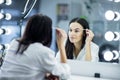 Womem in mirror clean make-up eyebrows Royalty Free Stock Photo