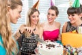 Woman blowing out candles on her birthday cake while celebrating Royalty Free Stock Photo