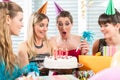 Woman blowing out candles on her birthday cake while celebrating Royalty Free Stock Photo