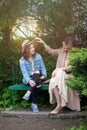 Beautiful women chatting in park on greenery foliage background