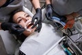 Beautiful woman in dental chair during procedure of installing braces to upper and lower teeth