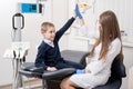 Beautiful woman dentist giving his little patient a high five