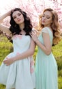 Beautiful women in elegant dresses posing in blossom garden Royalty Free Stock Photo