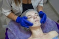 Beauty Clinic.woman gets a professional facial procedure. Beautician makes massage on a woman`s face. face renewal