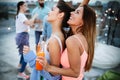 Beautiful women friends on the balcony having fun at party.