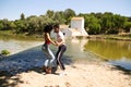 beautiful woman and handsome man latinos dancing bachata are dancing by the river in the forest. The couple do different postures