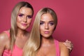 Beautiful women portrait. Two blonde girls on pink Royalty Free Stock Photo