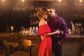 Woman in red dress hugs with her man in bar Royalty Free Stock Photo