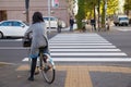 Women ride a bicycle on the footpath and waiting traffic light for cross the road