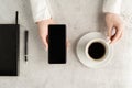 Beautiful women`s hands with up-to-date smartphone, notebook, fountain pen and cup of coffee on concrete background Royalty Free Stock Photo