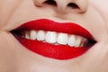 Beautiful women`s lips with bright red lipstick and white teeth. Royalty Free Stock Photo