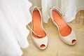 Beautiful women`s nude pump shoes with orange-red insoles, top-view with part of white cloth blurry in foreground Royalty Free Stock Photo