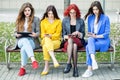 Beautiful women sit with gadgets on the bench. The concept of the Internet, social networks, study and lifestyle Royalty Free Stock Photo