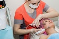 A beautiful woman takes a cosmetic procedure to improve the condition of the facial skin with microcurrents