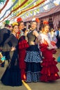 Beautiful women in traditional and colorful dress enjoy April Fair, Seville Fair Feria de Sevilla. Royalty Free Stock Photo