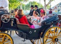 Beautiful women in traditional and colorful dress travelling in a horse drawn carriages at the April Fair, Seville Fair Royalty Free Stock Photo